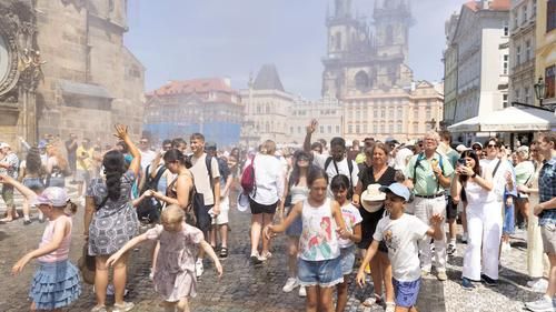 Людей в Праге обливают водой, чтобы охладить в жаркий солнечный день