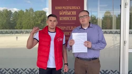 Депутат Госсовета от КПРФ Николай Удоратин (справа) и первый секретарь Коми республиканского отделения ЛКСМ РФ Вячеслав Кочев (слева) передают документы в Избирательную комиссию Республики Коми, 25 мая 2026 года 